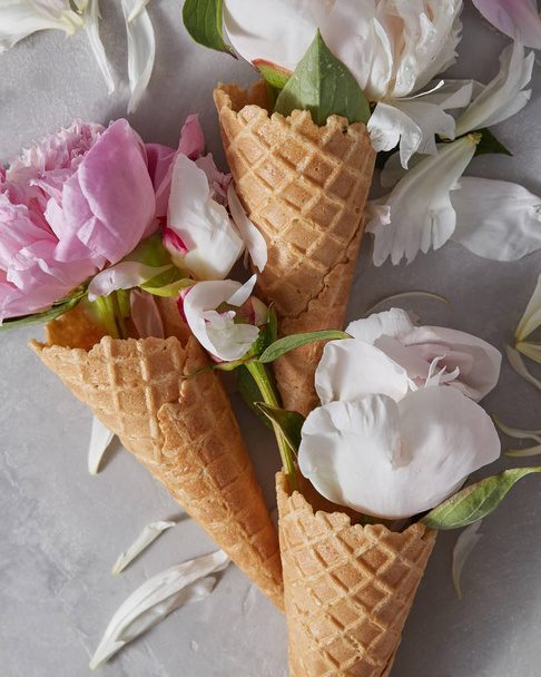 white and pink buds and petals of peonies in waffle cones  - Φωτογραφία, εικόνα