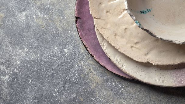 Porcelain bowls and plates on gray concrete table. Ceramic vintage handmade dishes. Flat lay - Photo, Image