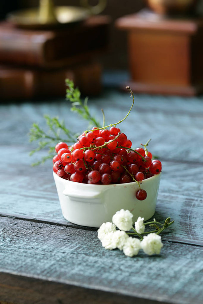 red currant in a cup on a wooden table - Photo, Image