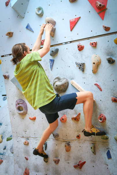Teini-ikäinen poika koulutus kiipeily sisätiloissa kiipeily seinään
 - Valokuva, kuva