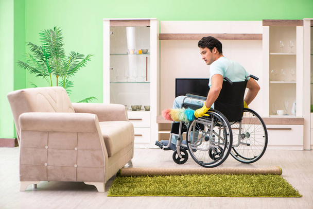 Disabled man on wheelchair cleaning house - Foto, imagen