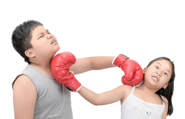 Irmão e irmã lutando com luvas de boxe vermelho isolado no fundo branco
. - Foto, Imagem