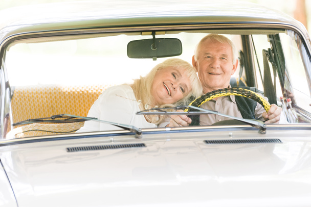 senior woman embracing man in beige car - Foto, Imagem