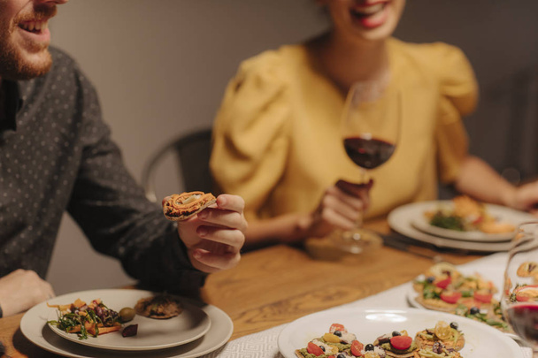 Man and woman eating and drinking wine at home dinner party. - Foto, immagini