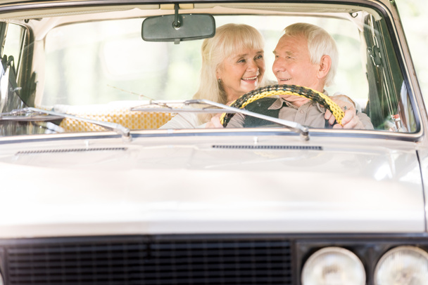 hermosa mujer mayor abrazando hombre en coche vintage
 - Foto, imagen