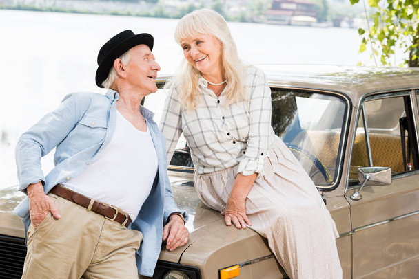 stylish senior man near woman sitting on beige car - Fotografie, Obrázek