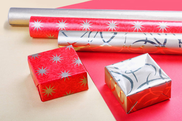 Χρυσή κουτιά δώρων και κόκκινο χαρτί περιτυλίγματος σε φωτεινό φόντο.Top view επίπεδη lay αντικείμενα ομάδα - Φωτογραφία, εικόνα