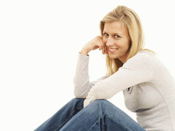 Woman sitting and smiling in studio  - Фото, зображення