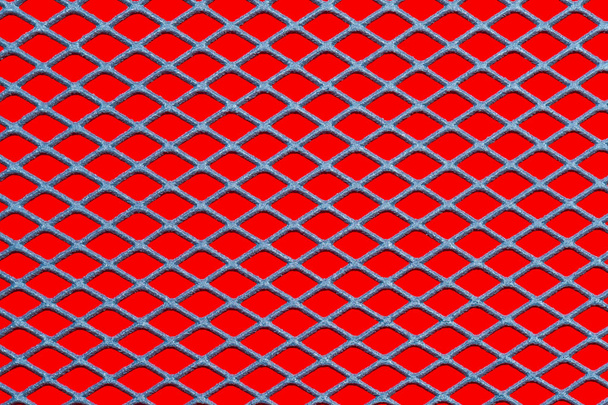 Μεταλλικό πλέγμα πλέγμα σε κόκκινο φόντο - Φωτογραφία, εικόνα