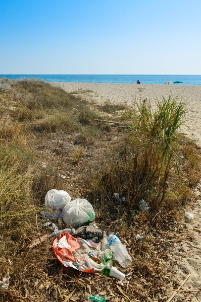 pollution of a rubbish abandoned on a beach by the sea - Photo, Image