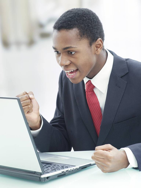 Businessman using laptop in office and screaming with happiness  - Foto, Bild