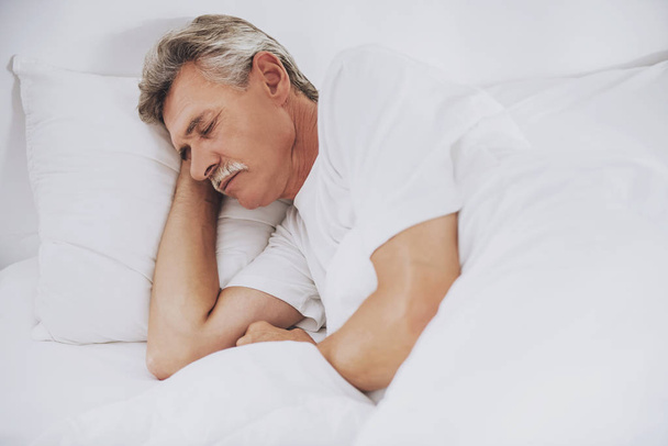 Old Man Sleeping in Comfortable White Bed at Home. - Φωτογραφία, εικόνα