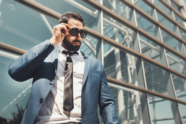 Bearded Businessman Wears Sunglasses Before Modern Building - Fotografie, Obrázek