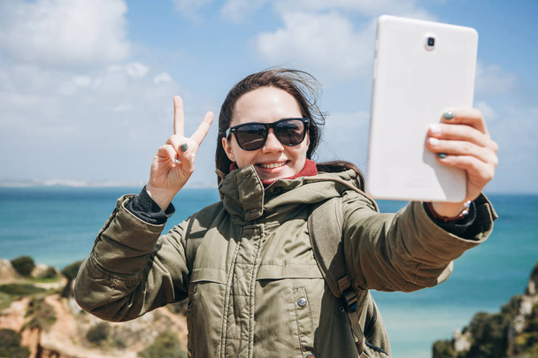 Молодая женщина турист или блоггер общается на планшете через Интернет
 - Фото, изображение