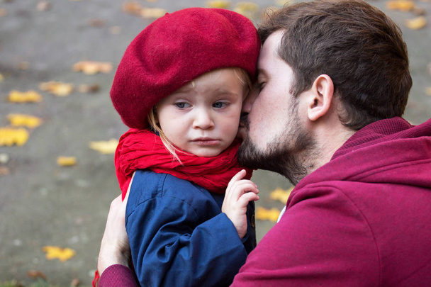 Dad is kissing his crying daughter. Close up, autumn time. - Foto, imagen