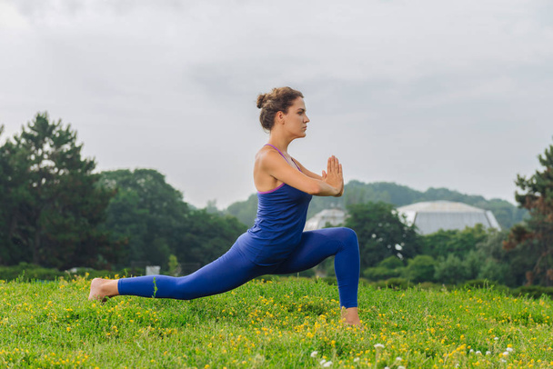 Fitness woman feeling harmony while balancing and stretching - Valokuva, kuva