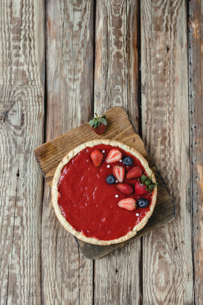 top view of delicious red strawberry pie on cutting board - Photo, Image