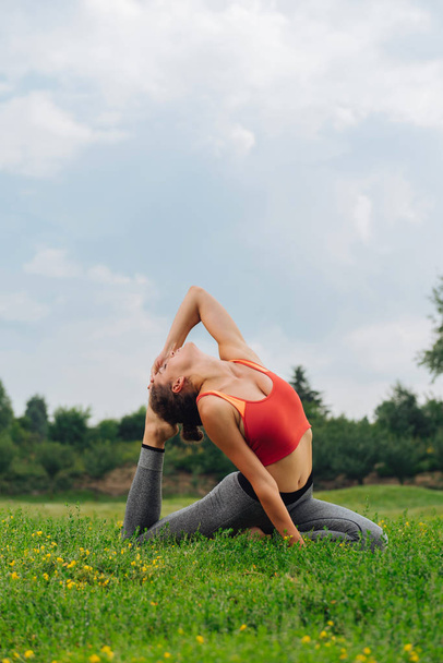 Slim athletic woman appreciating peaceful atmosphere during yoga - Фото, изображение