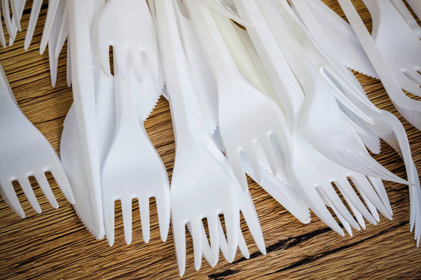 Plastik çatal ve bıçaklar bir ahşap yüzeye - Fotoğraf, Görsel