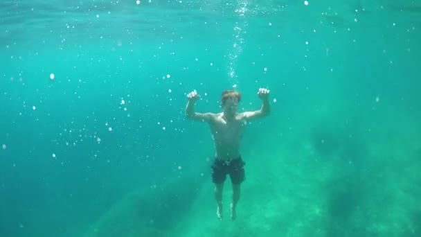 Lassú mozgás, szorosan fel, víz alatti: Fiatal férfi fulladás a mély óceán, a sziklás óceán aljára süllyed. Így az áldozat száját a légbuborékok. Tapasztalatlan rossz úszó szembe kell néznie a szörnyű és fájdalmas halált - Felvétel, videó