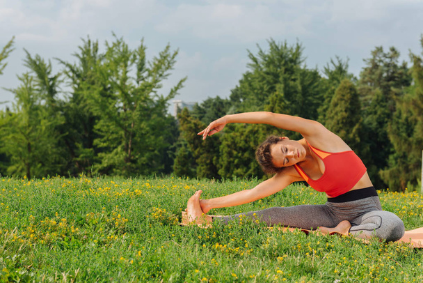 Slim sportswoman doing yoga for abs sitting on mat - Foto, Imagem