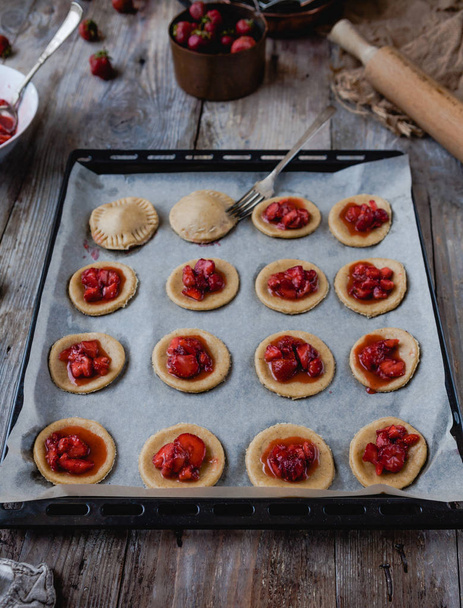unprocessed cookies with strawberries and fork on tray - Photo, Image