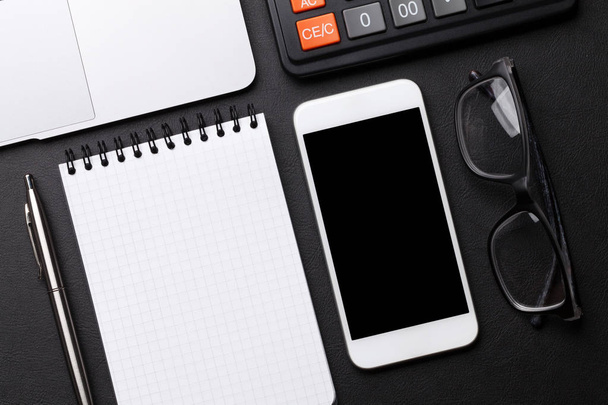 boş defter, kalem, hesap makinesi, Gözlük, smartphone ve siyah arka plan üzerine laptop. Kopya alanı ile üstten görünüm  - Fotoğraf, Görsel