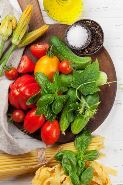 Verse tuin tomaten en komkommers met kruiden koken op houten tafel. Bovenaanzicht - Foto, afbeelding