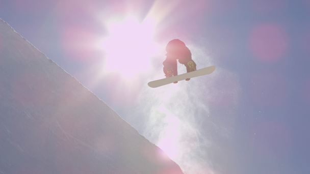 Slow Motion: Mladí pro snowboardista na koni rampě v big mountain snow parku, skákání z halfpipe zdi a nad slunce, provádění triků a střídání s drapáky v slunných zimních - Záběry, video
