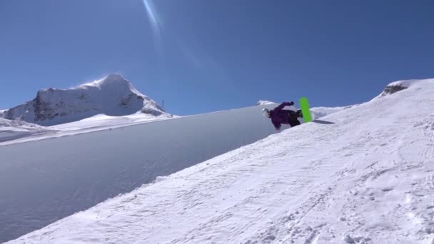 SLOW MOTION: Giovane snowboarder professionista che cavalca la mezza pipa in un grande snowpark di montagna, salta in alto dal muro dell'halfpipe, eseguendo trucchi e rotazioni con prese in inverno soleggiato
 - Filmati, video