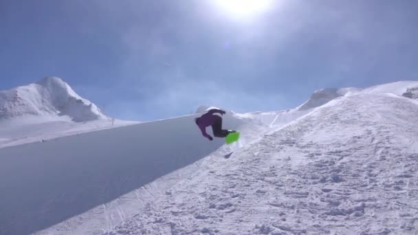 Lassú mozgás: Fiatal pro snowboardos, a fél cső a nagy hegy snow park lovaglás, jumping magas a félcső falból, teljesítő trükkök és fordulatszám és megragadja a napsütéses téli - Felvétel, videó