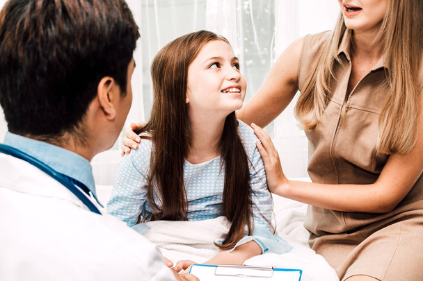 Arzt berät und überprüft Informationen mit kleinen Mädchen und Mutter im Krankenhaus. Ein kleines Mädchen hat Krankheit. Gesundheitsfürsorge und Medizin - Foto, Bild
