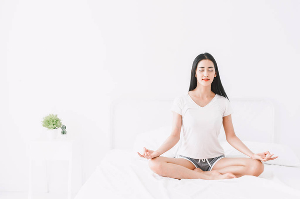 Woman practicing yoga at home in bedroom - Photo, image