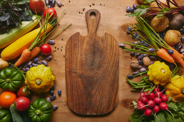 Cutting board with summer vegetables on wooden table - Photo, Image