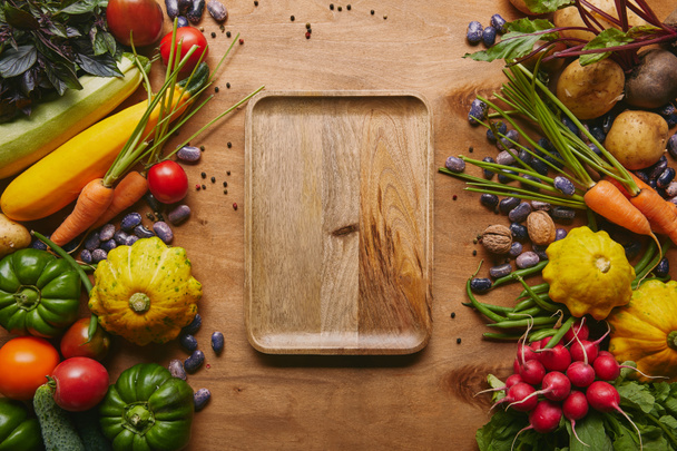 Organic raw vegetables with tray on wooden table - Photo, Image