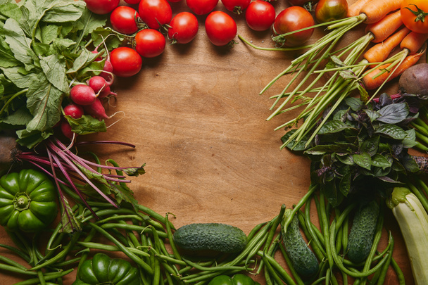Frame of healthy green and red vegetables on wooden table - Fotó, kép