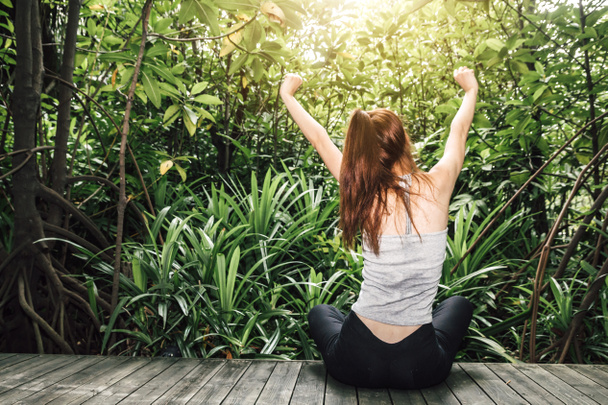 Femme étirer ses bras se détendre et profiter avec la nature verte air frais
 - Photo, image