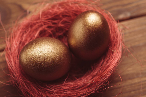 golden easter eggs on wooden table - Foto, afbeelding
