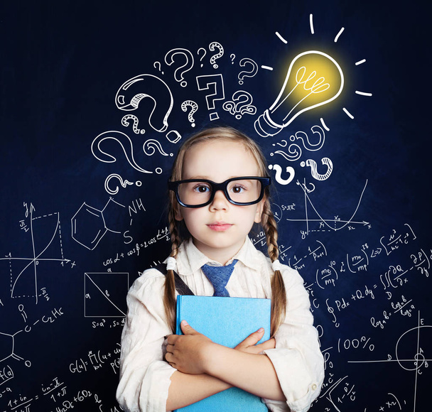 Cheerful child at the blackboard with lightbulb and mathematics formulas. Problem and solution. Ideas concept - Photo, image