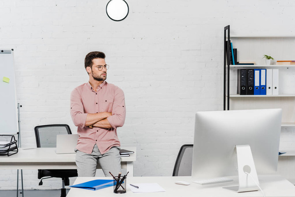 handsome young businessman leaning back at workplace at modern office - Photo, Image