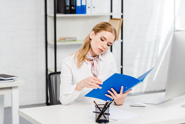 focused young businesswoman reading documents at modern office - Foto, Imagen