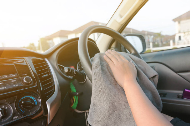 Mãos de mulher usando tecido de microfibra para limpar o interior do carro SUV
 - Foto, Imagem