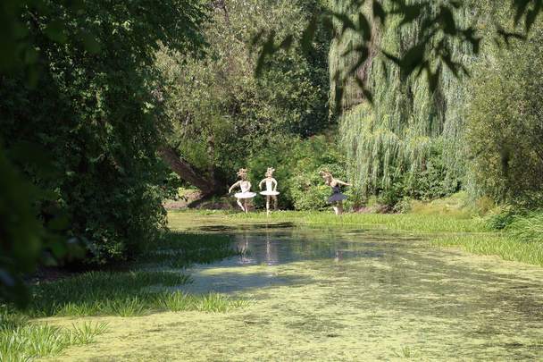 Una bailarina de tela sobre un estanque en el jardín botánico "Aptekarskiy Ogorod" en Moscú, Rusia
 - Foto, Imagen