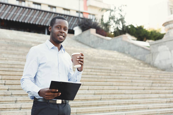 Portrait of a confident young black businessman with notepad - Фото, изображение