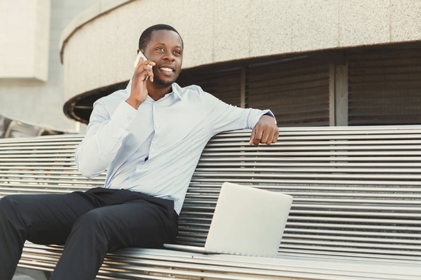 Homme d'affaires afro-américain travaillant avec un ordinateur portable à l'extérieur
 - Photo, image