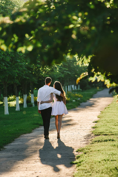 Young couple walking hugging each other in an evening park - Foto, immagini