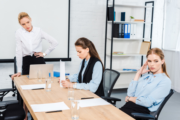 сердитая женщина-босс разговаривает с подавленными сотрудницами в современном офисе
 - Фото, изображение
