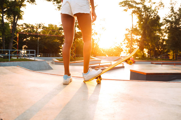 Cropped photo of young woman outdoors with skateboard. - Photo, Image