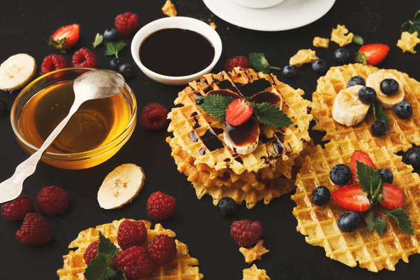 Waffles with berries and fruits, breakfast at black background - Photo, Image