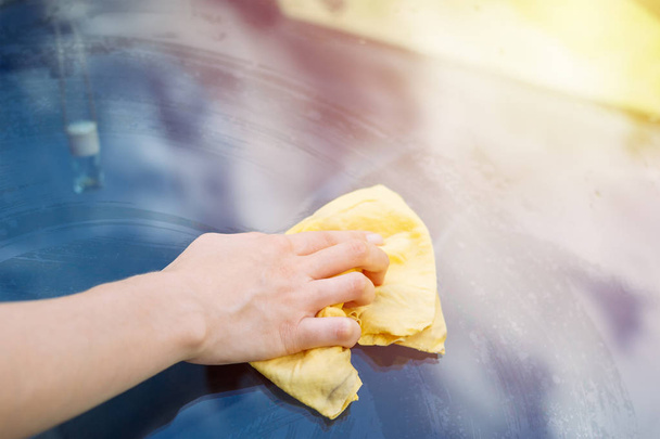 Жіноча рука очищення автомобіля скло з мікрофібри тканини крупним планом
 - Фото, зображення
